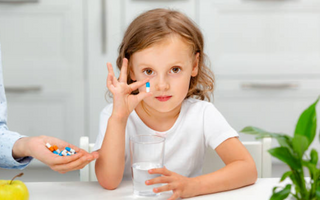 Child taking daily multivitamin before school