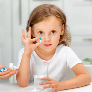 Child taking daily multivitamin before school